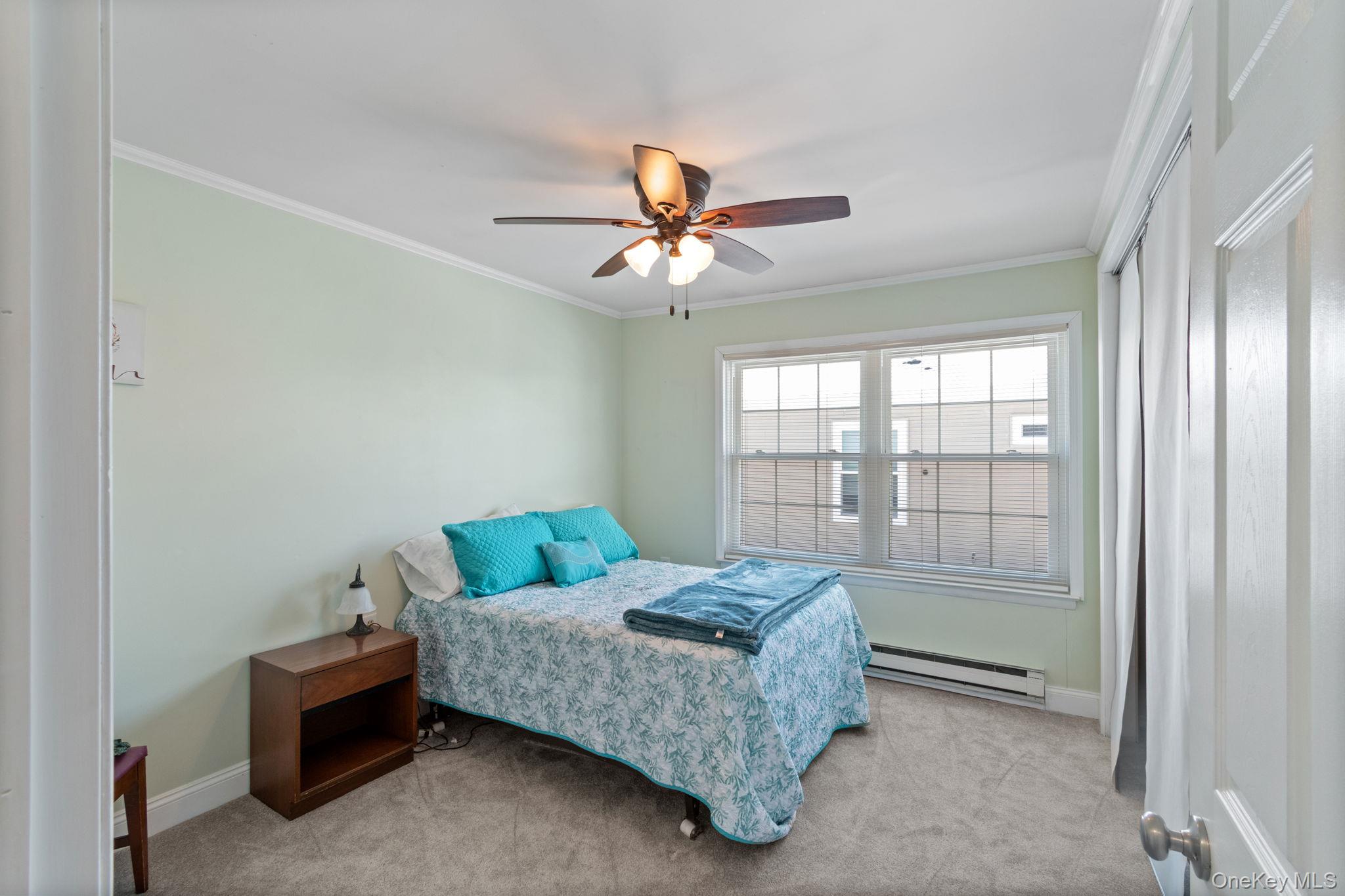 475 Stratford Lane Ridge, NY 11961 - Photo 11 of 16 a bedroom with a bed and a chandelier