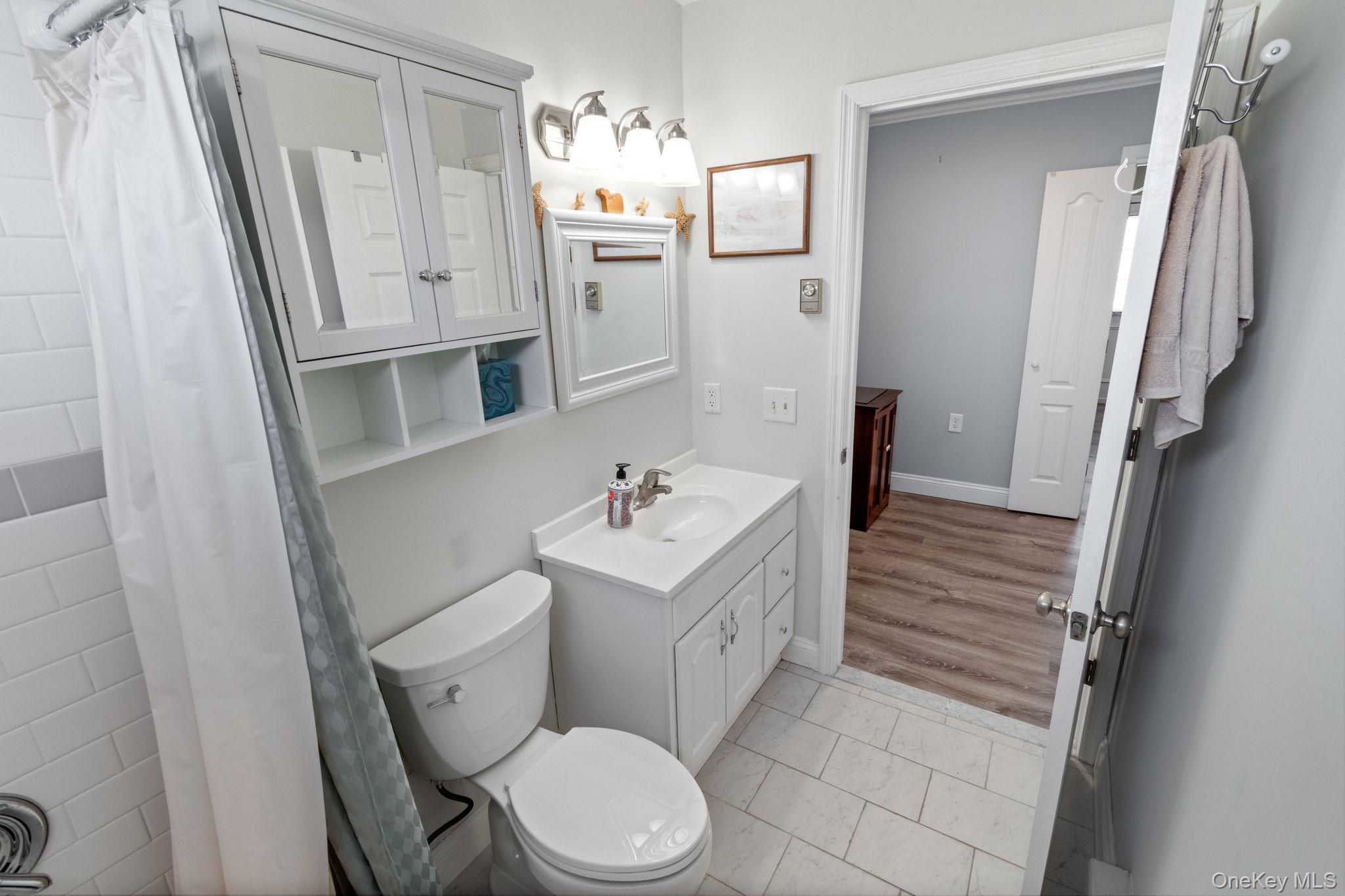 475 Stratford Lane Ridge, NY 11961 - Photo 12 of 16 a white toilet sitting next to a bathroom sink