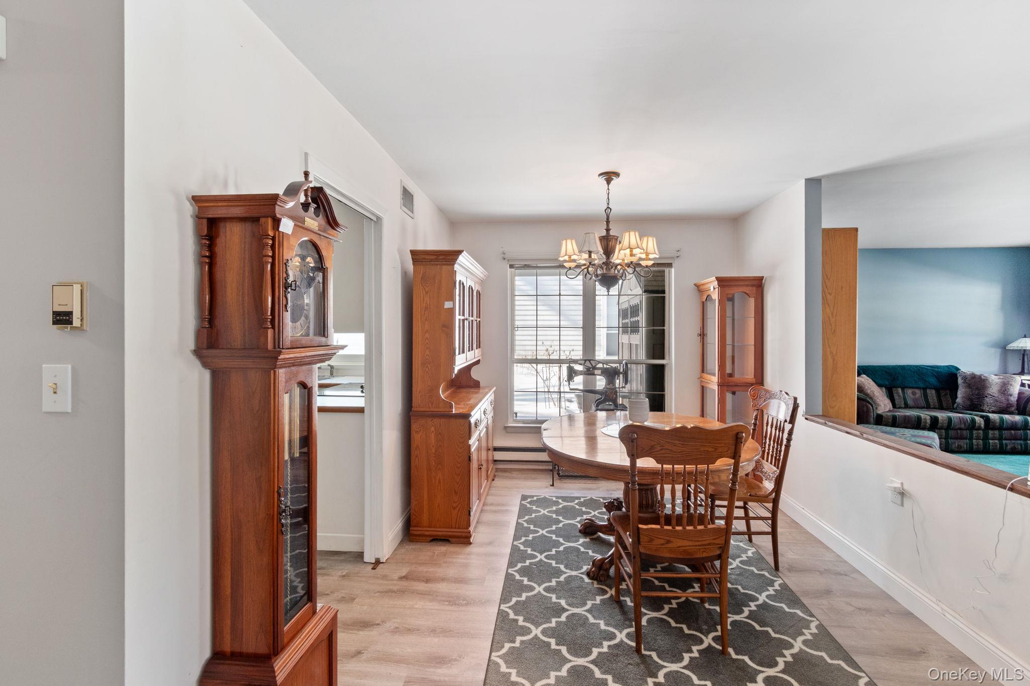 475 Stratford Lane Ridge, NY 11961 - Photo 5 of 16 a view of a dining room with furniture and chandelier