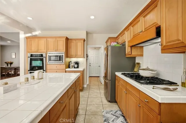 a large white kitchen with kitchen island granite countertop a large window and a sink
