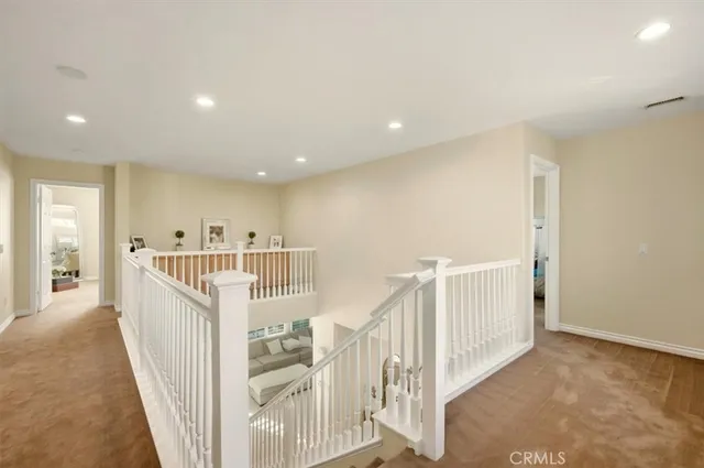 a view of a hallway with wooden floor and windows
