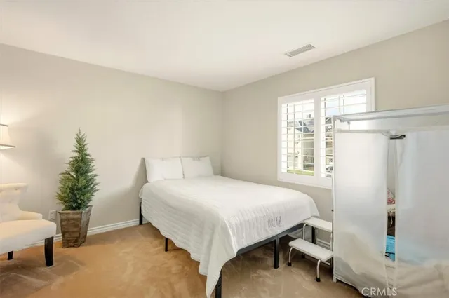 a spacious bedroom with a bed and a dresser