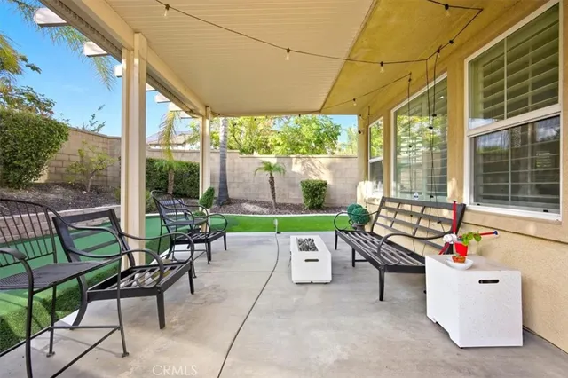 a view of a patio with a table chairs and a backyard