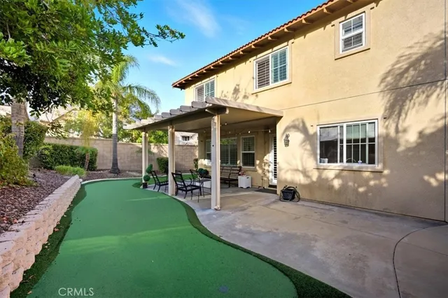 a view of a patio with a table and chairs under an umbrella