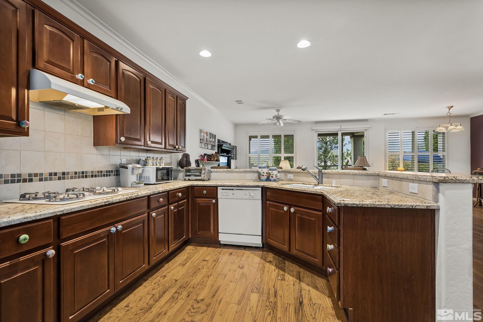 1355 Tarleton Way Reno, NV 89523 - Photo 10 of 40 a kitchen with stainless steel appliances granite countertop wooden cabinets a sink and dishwasher a oven with wooden floors