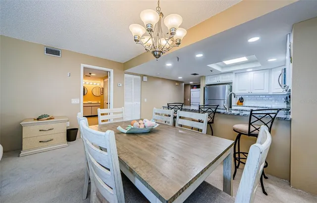 a kitchen with stainless steel appliances granite countertop a sink a stove and chairs
