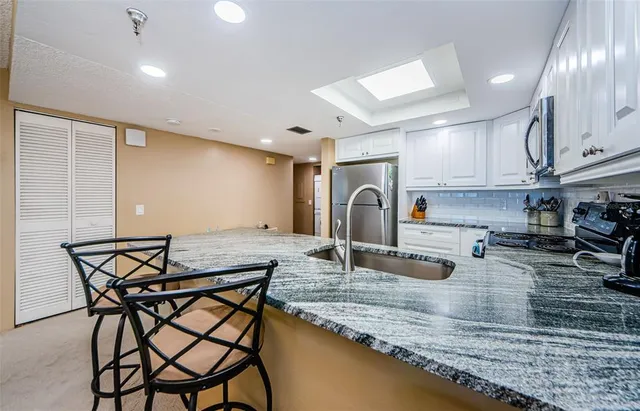 a kitchen with stainless steel appliances granite countertop a refrigerator and a stove top oven