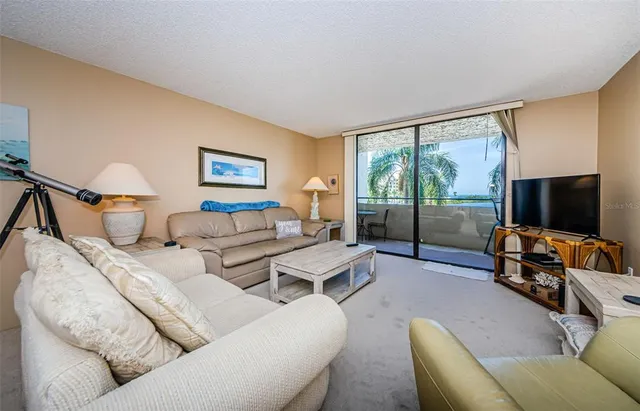 a living room with furniture a chandelier and a window