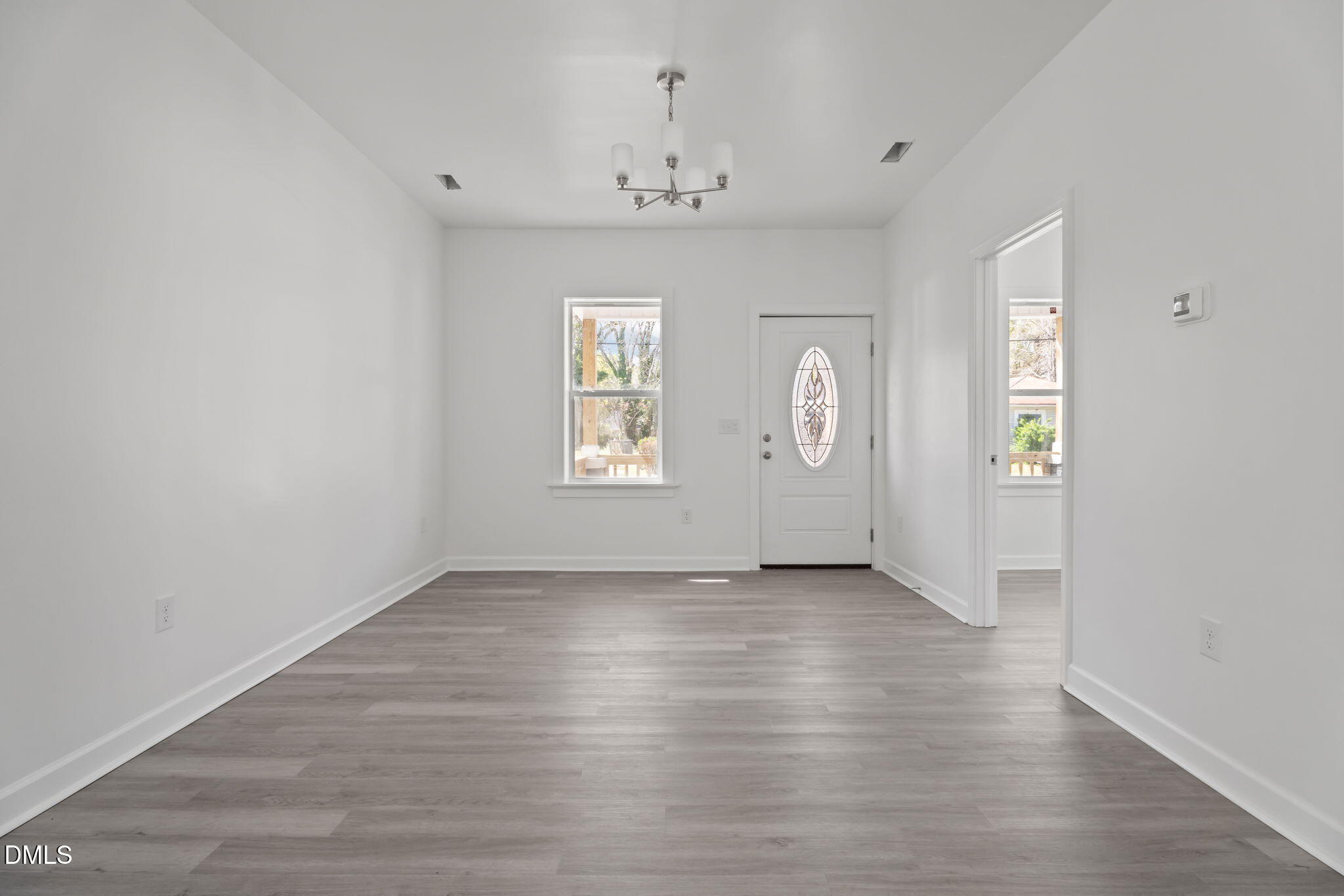 910 Gay Street Rocky Mount, NC 27804 - Photo 5 of 18 an empty room with wooden floor chandelier and windows