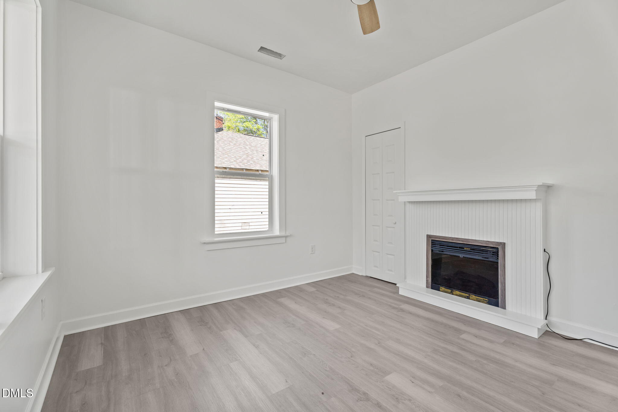 910 Gay Street Rocky Mount, NC 27804 - Photo 8 of 18 an empty room with wooden floor fireplace and windows