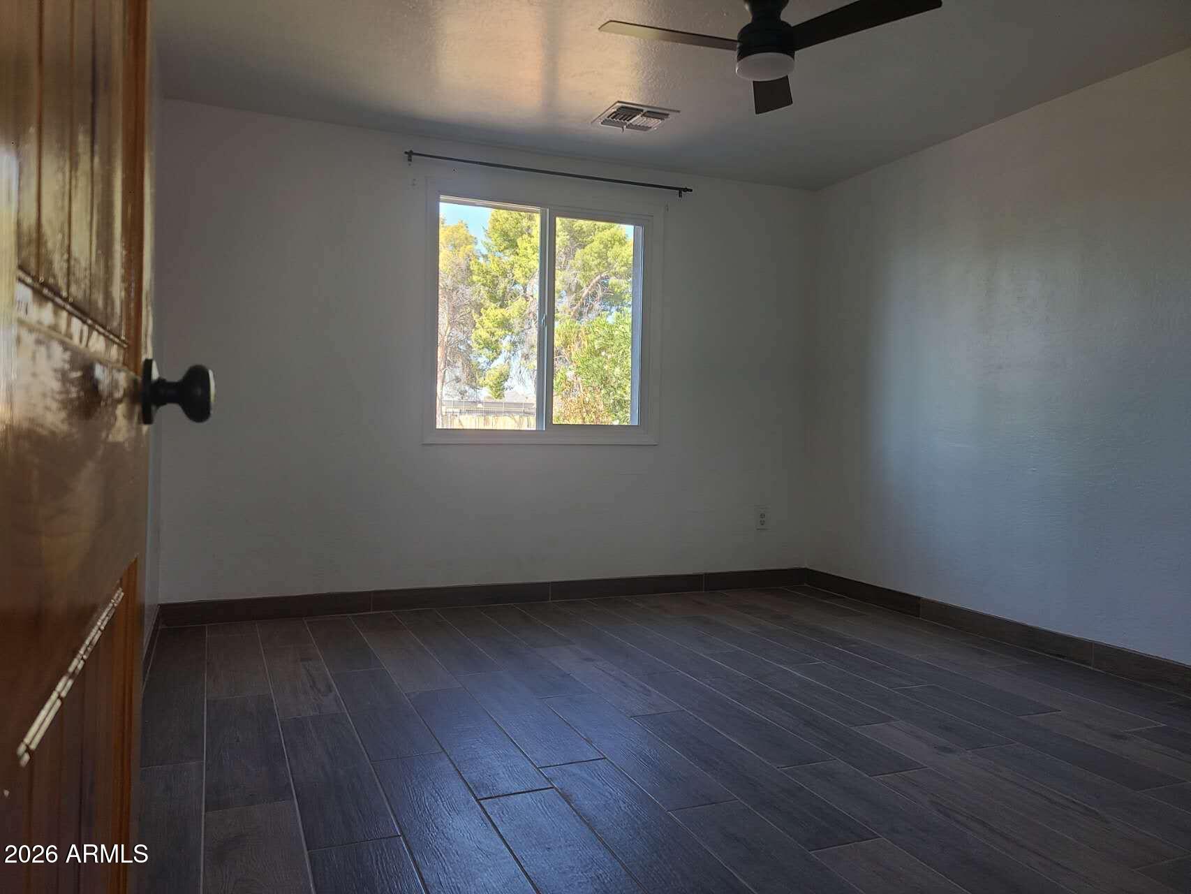3702 East Thunderbird Road Phoenix, AZ 85032 - Photo 13 of 23 an empty room with wooden floor and windows