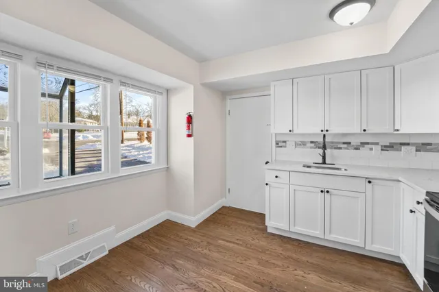 a kitchen with granite countertop white cabinets and sink