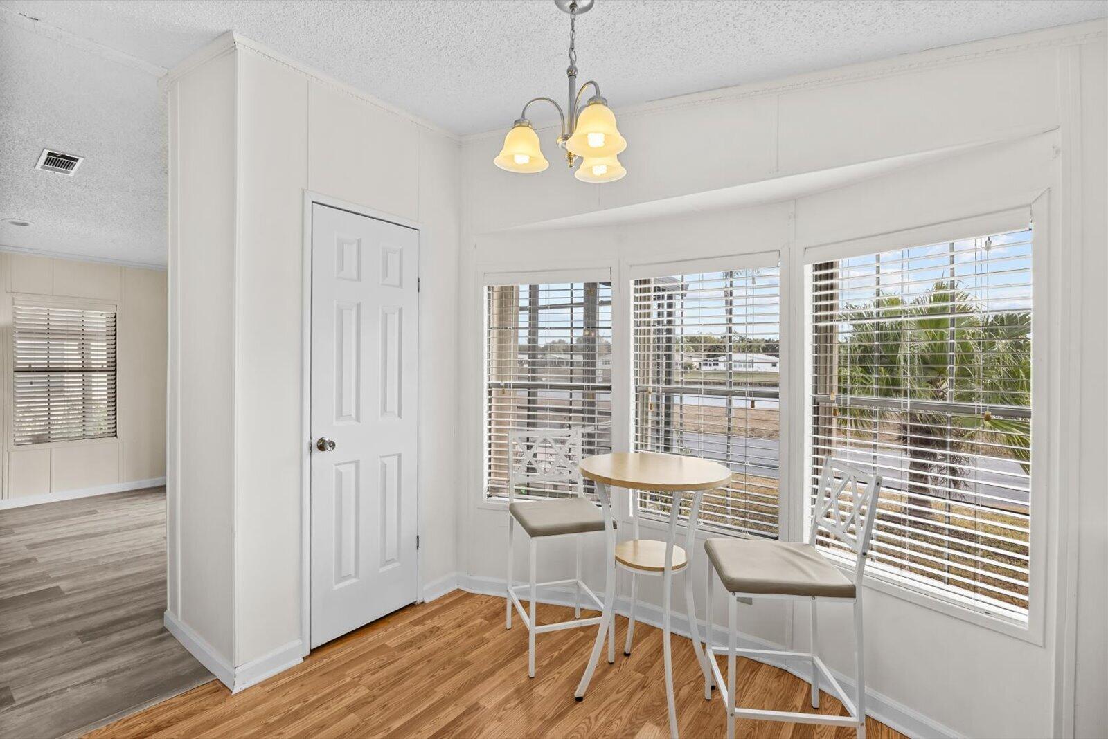 507 Tropical Isles Circle, Unit 25 Fort Pierce, FL 34982 - Photo 11 of 24 a view of a dining room with furniture wooden floor and a chandelier
