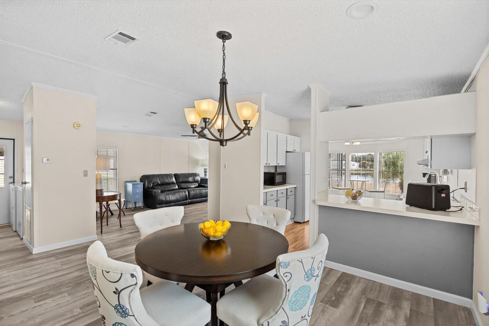 507 Tropical Isles Circle, Unit 25 Fort Pierce, FL 34982 - Photo 7 of 24 a view of a dining room with furniture wooden floor and chandelier