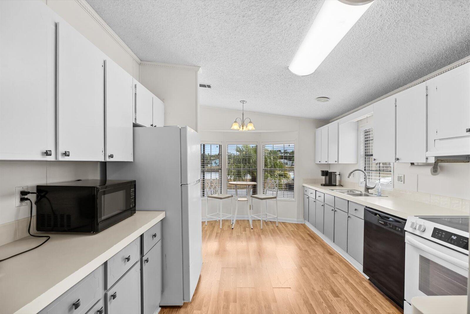 507 Tropical Isles Circle, Unit 25 Fort Pierce, FL 34982 - Photo 8 of 24 a kitchen with white cabinets and white appliances