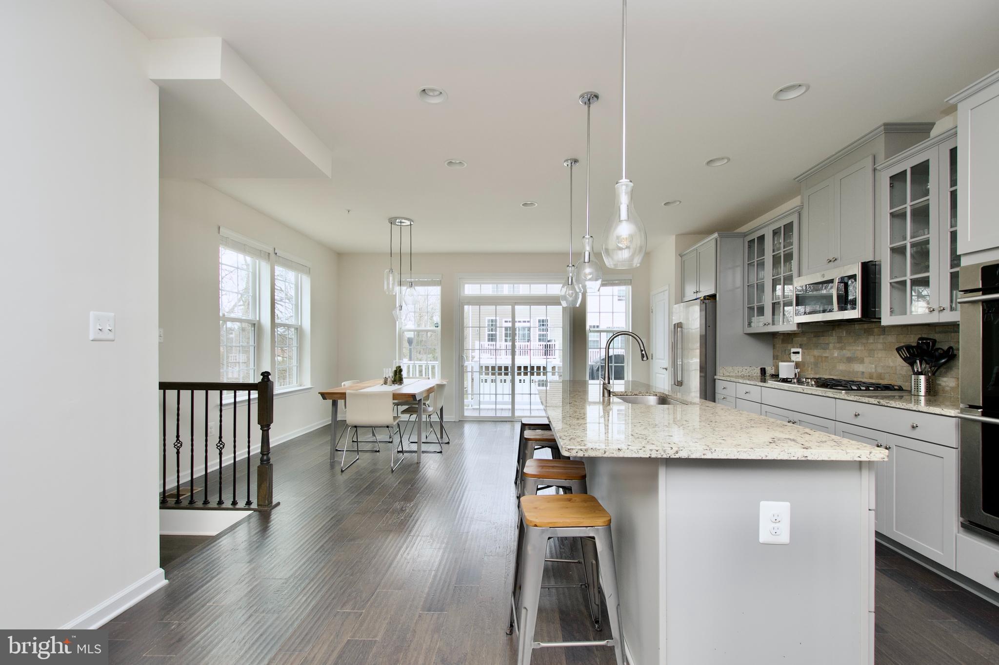 2900 Pinebrook Road Landover, MD 20785 - Photo 16 of 46 a kitchen with stainless steel appliances granite countertop a stove a sink a refrigerator and white cabinets with wooden floor