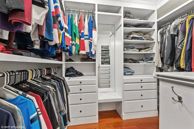 a view of walk in closet with clothes and shoes