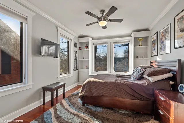 a bedroom with a bed painting on wall and a large window