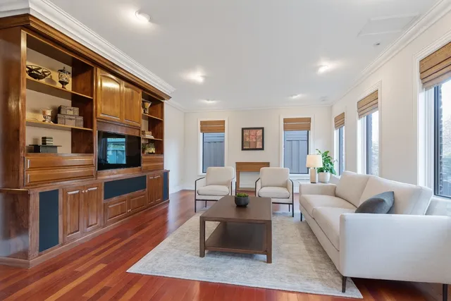 a living room with furniture fireplace and wooden floor