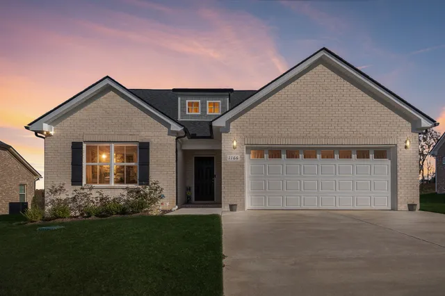 a front view of a house with a yard and garage