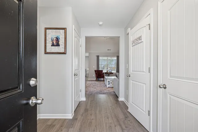 a view of a hallway with wooden floor and closet