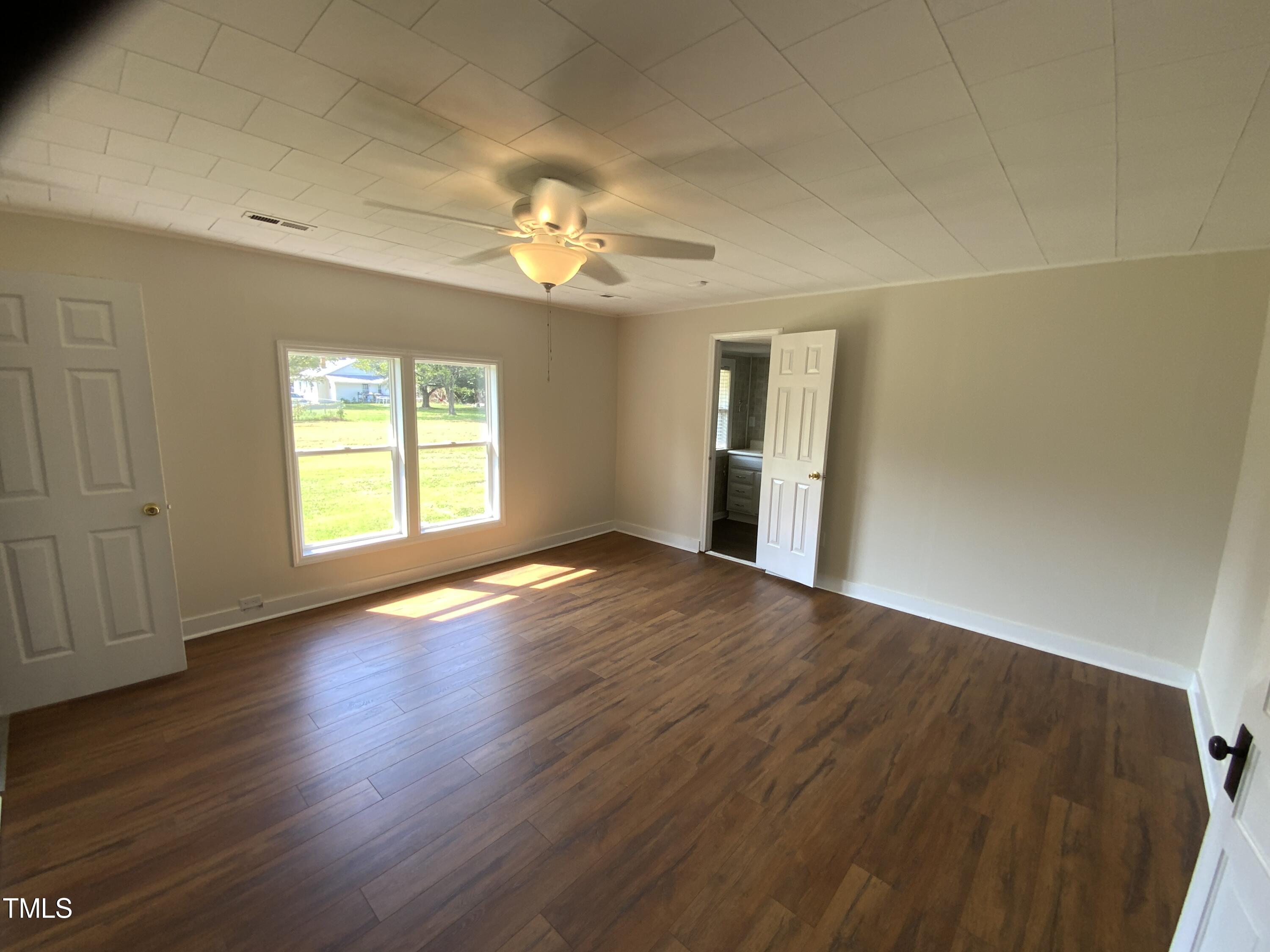 235 East Jackson Street Coats, NC 27521 - Photo 12 of 17 an empty room with wooden floor chandelier and windows