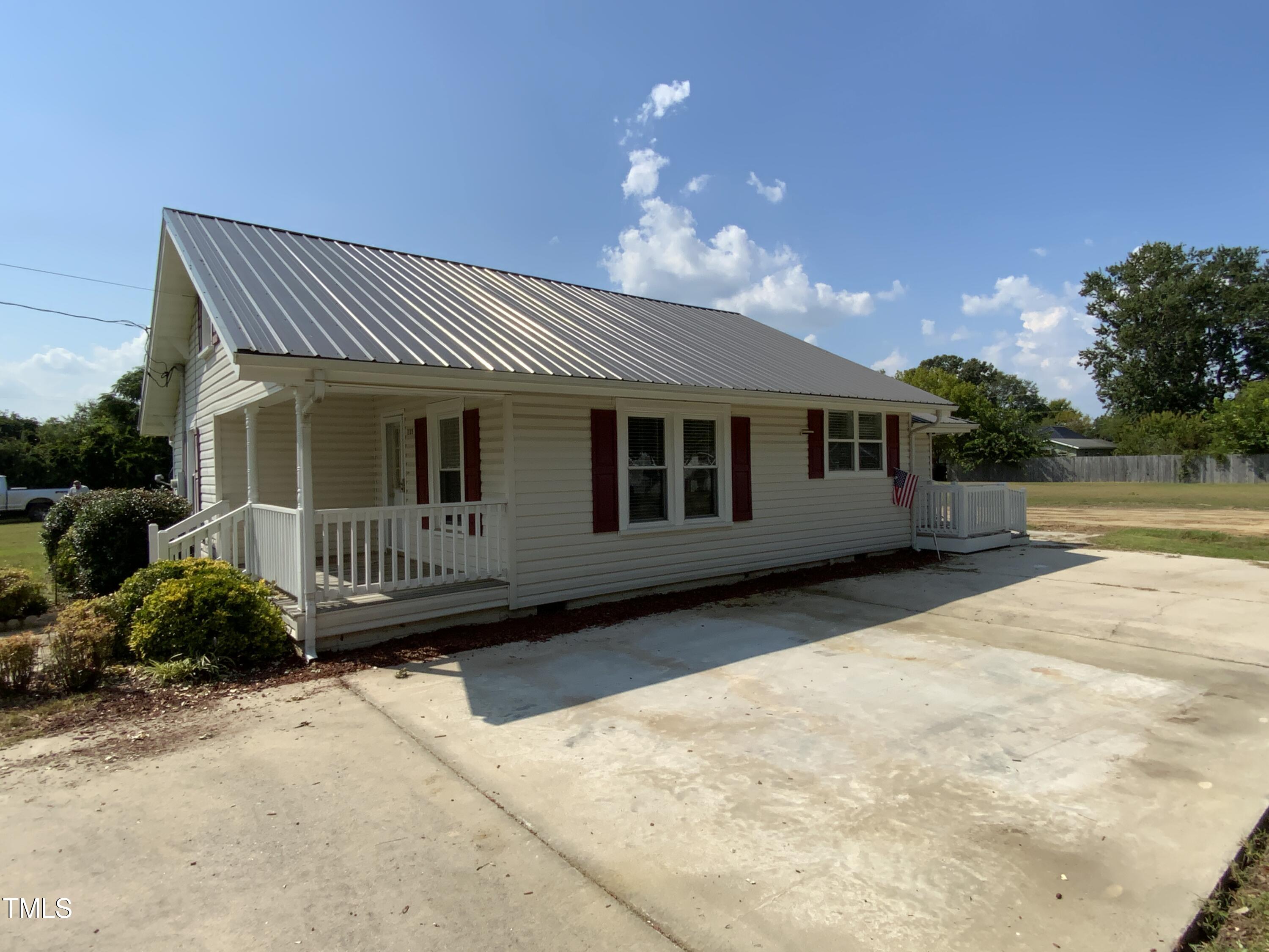 235 East Jackson Street Coats, NC 27521 - Photo 2 of 17 a porch with furniture and garden