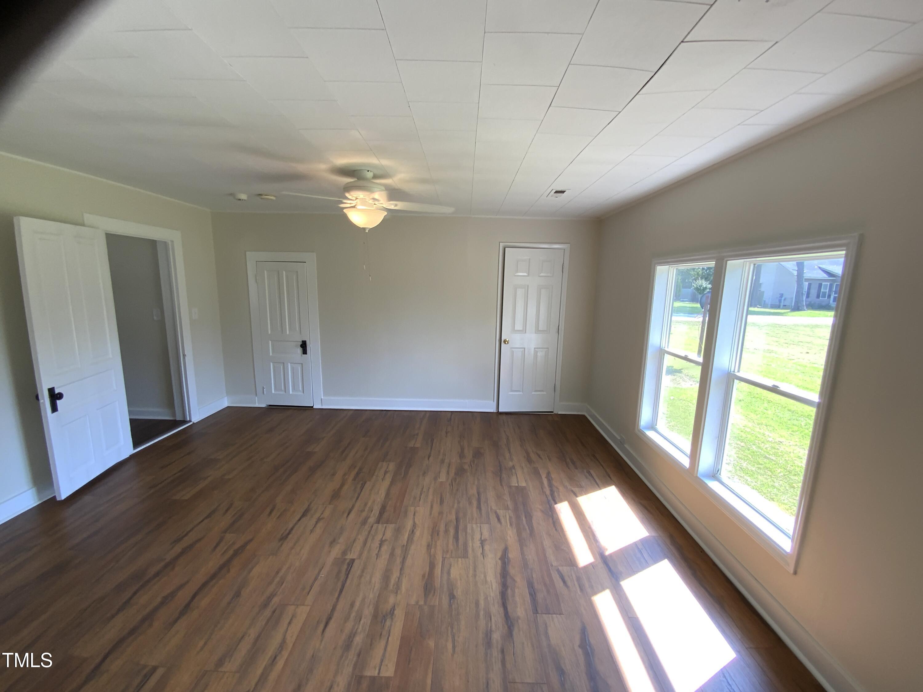 235 East Jackson Street Coats, NC 27521 - Photo 6 of 17 a view of empty room with wooden floor and fan