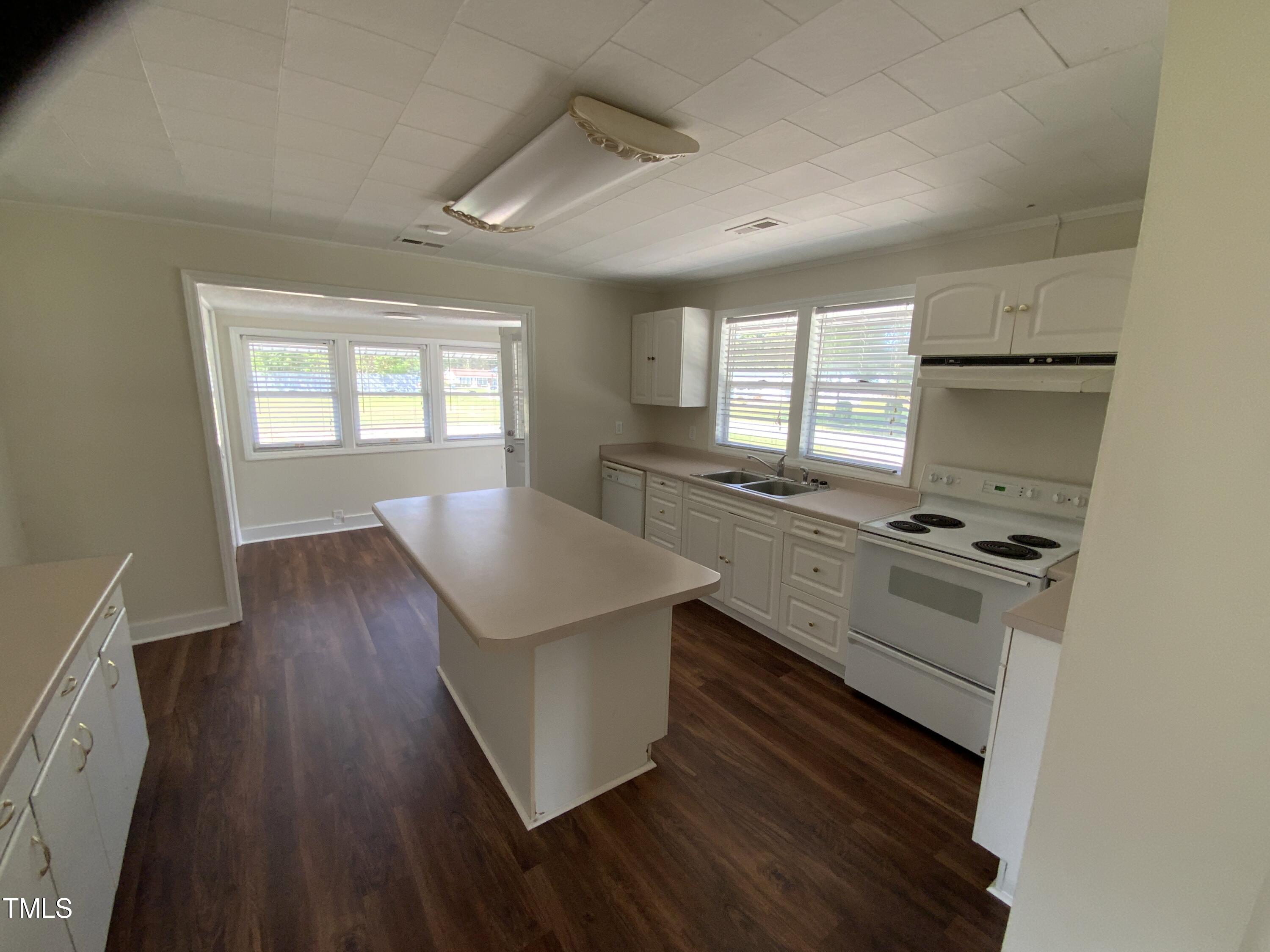 235 East Jackson Street Coats, NC 27521 - Photo 7 of 17 a kitchen with wooden floors and white appliances
