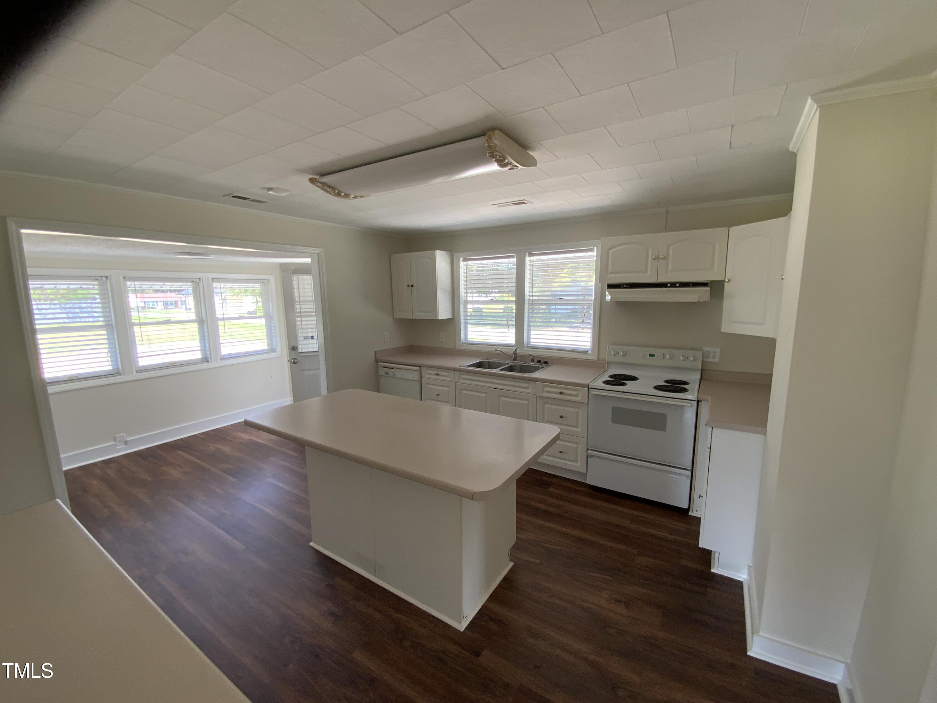 235 East Jackson Street Coats, NC 27521 - Photo 8 of 17 a kitchen with cabinets wooden floor and stainless steel appliances
