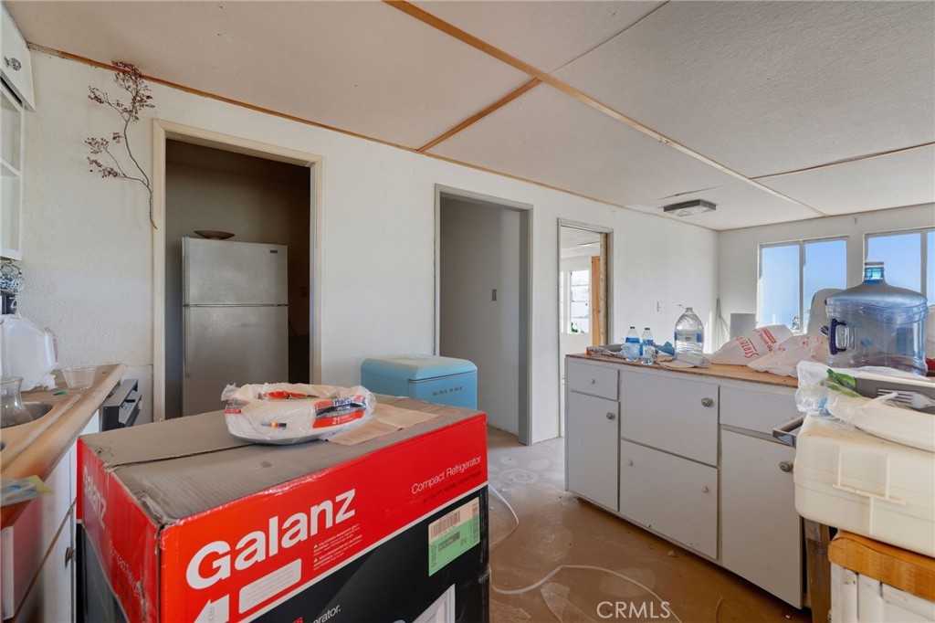 83626 Carey Road Twentynine Palms, CA 92277 - Photo 21 of 30 a kitchen with a sink stove and wooden cabinets
