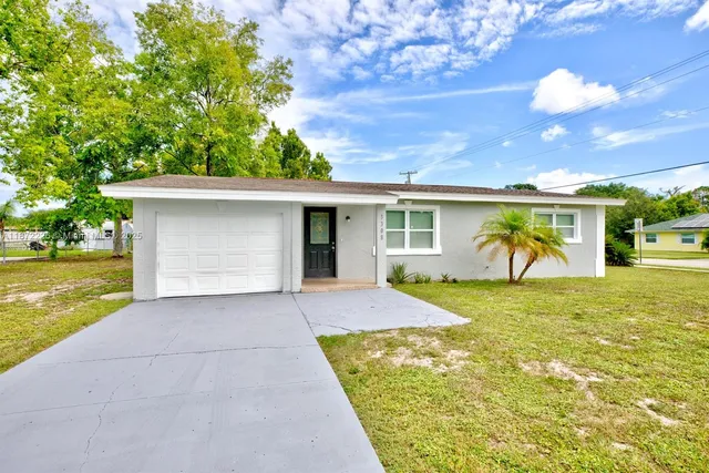 a view of a house with a yard and garage