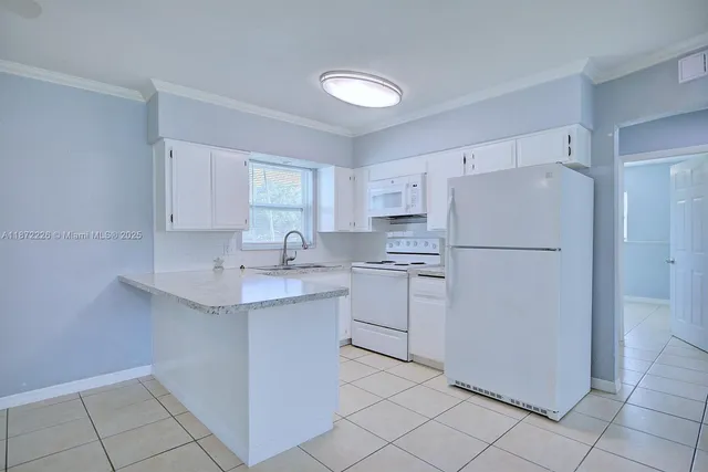 a kitchen with appliances a sink and cabinets