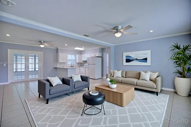 a living room with furniture potted plant and kitchen view