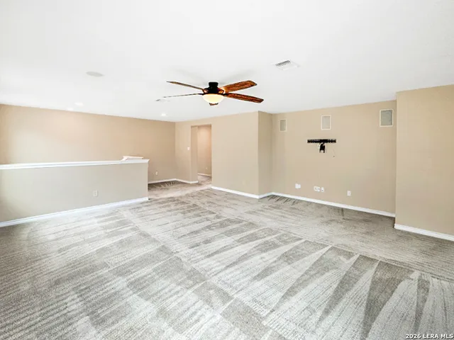 a view of a room with a ceiling fan