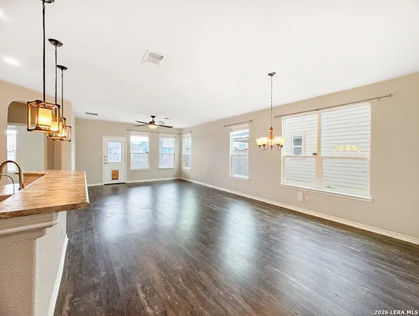 a view of a kitchen with kitchen island a sink wooden floor and a large window
