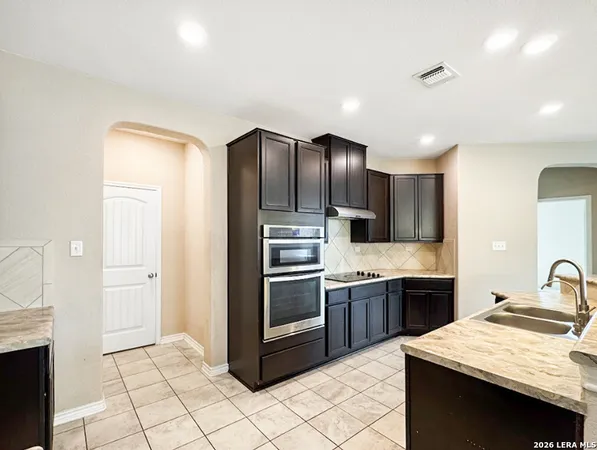 a kitchen with stainless steel appliances granite countertop a sink and a refrigerator