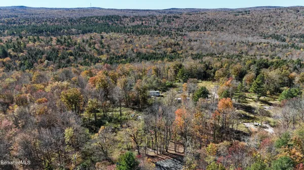 an aerial view of residential houses with outdoor space and trees