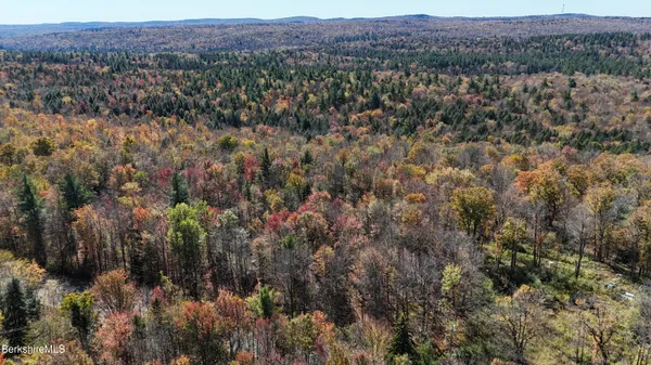 an aerial view of house with yard and mountain view in back