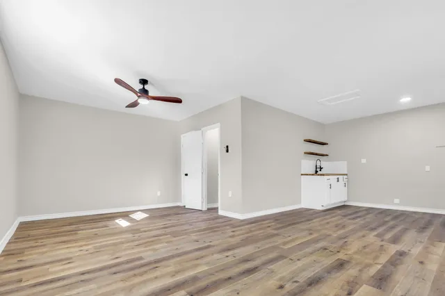 a view of empty room with wooden floor and window