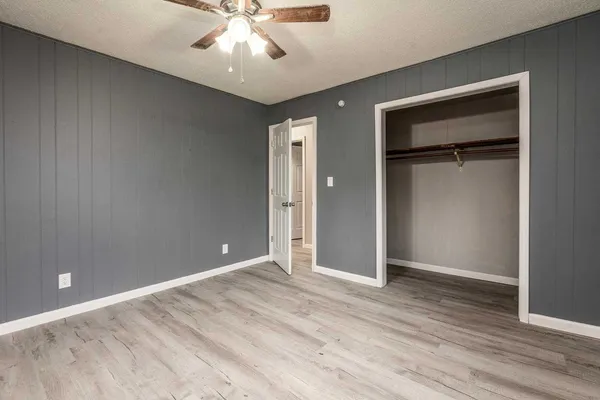 an empty room with wooden floor and closet area