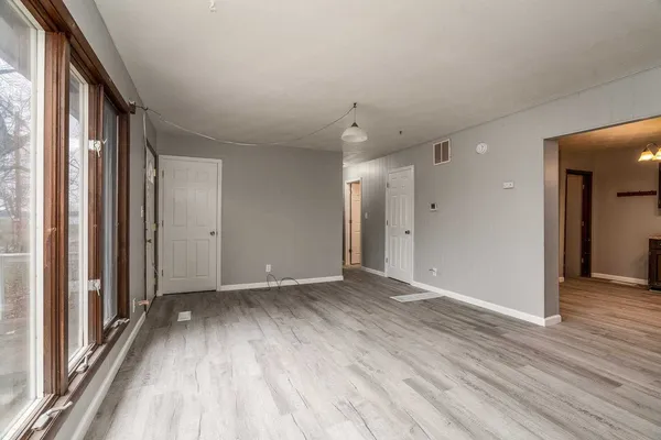a view of hallway with a large window and wooden floor