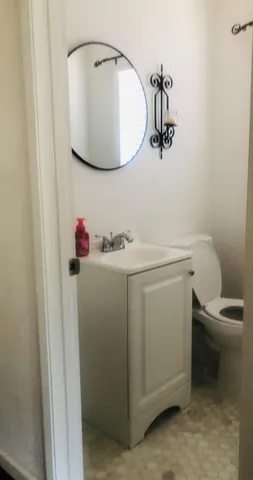 a bathroom with a sink toilet and mirror