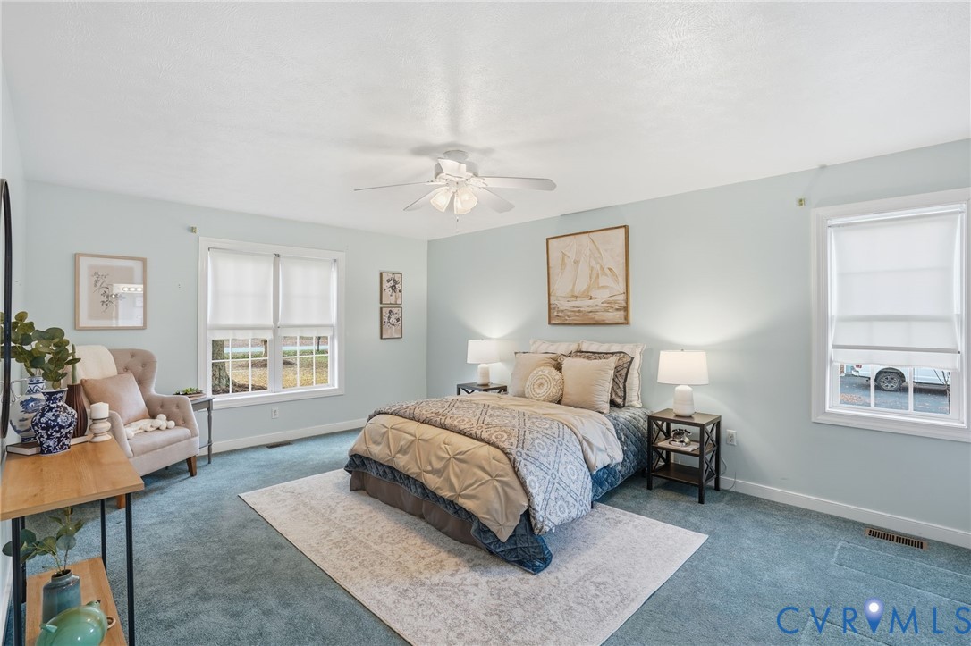 8420 Lee Davis Road Mechanicsville, VA 23116 - Photo 18 of 42 a spacious bedroom with a bed a couch and windows