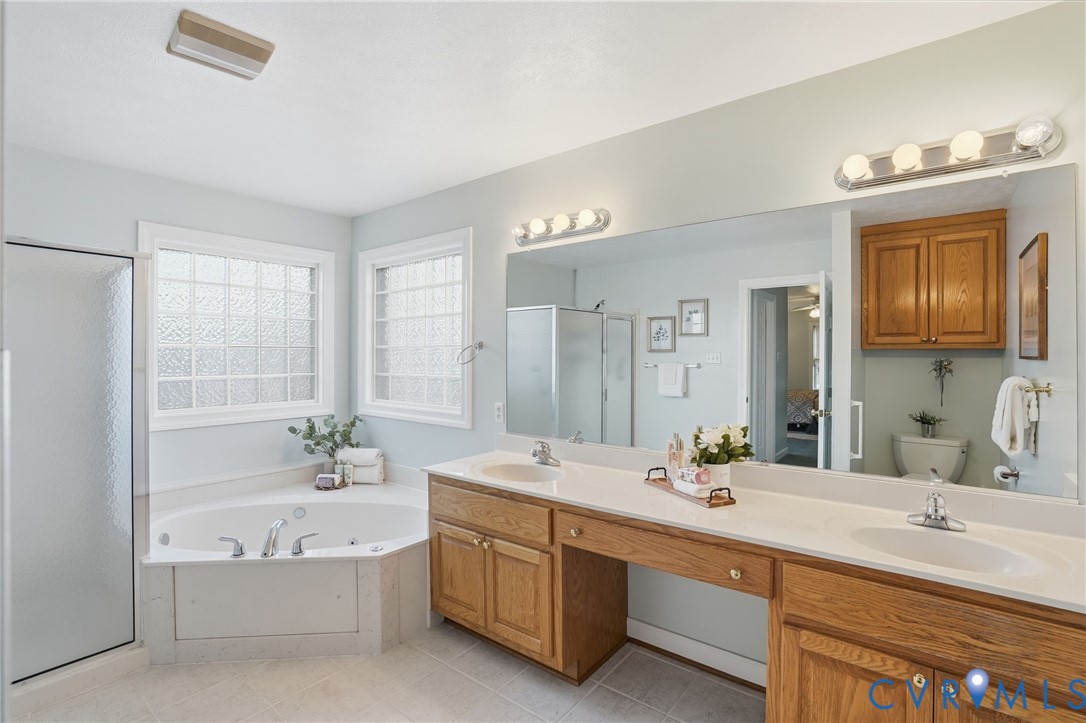 8420 Lee Davis Road Mechanicsville, VA 23116 - Photo 21 of 42 a bathroom with double vanity sinks a large mirror and a bathtub