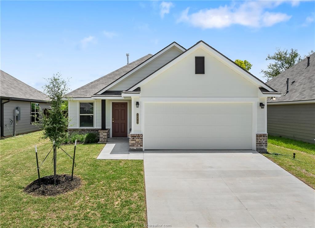 a front view of house with a yard and potted plants