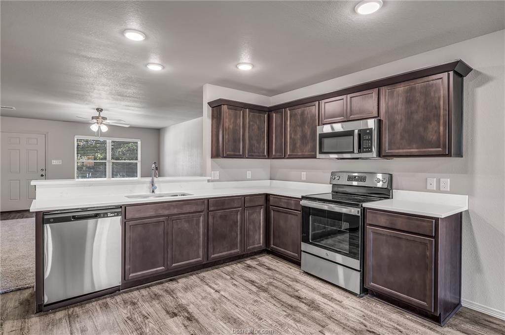 1629 Lucky Street Bryan, TX 77807 - Photo 4 of 11 a kitchen with stainless steel appliances granite countertop a sink stove and microwave