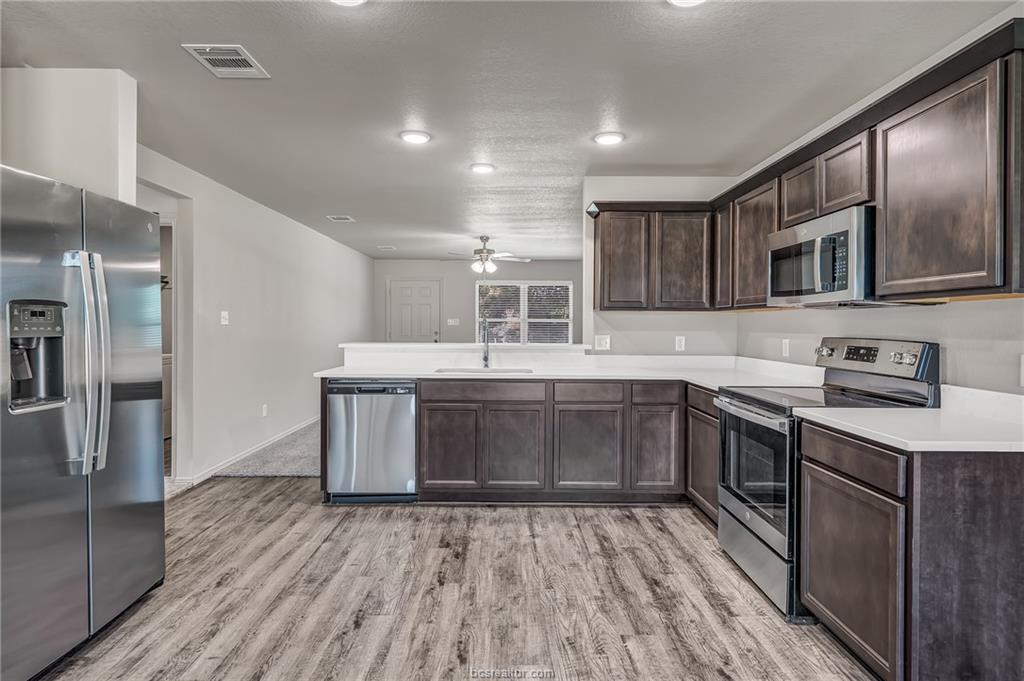 1629 Lucky Street Bryan, TX 77807 - Photo 5 of 11 a kitchen with stainless steel appliances granite countertop a sink and wooden cabinets