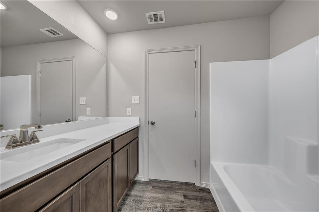 1629 Lucky Street Bryan, TX 77807 - Photo 10 of 11 a bathroom with a granite countertop tub sink and mirror