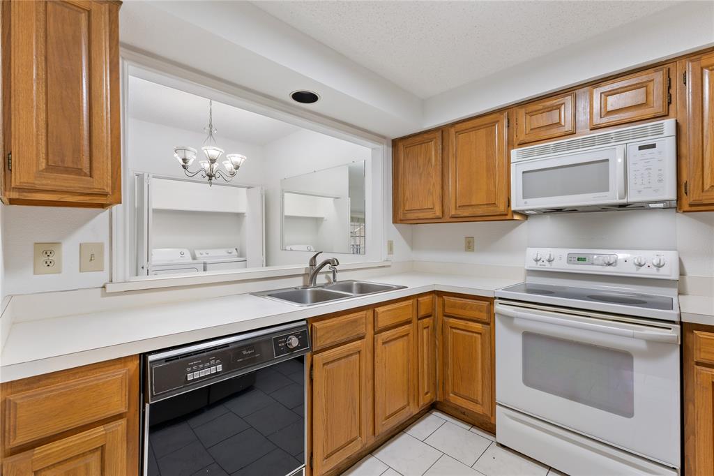 5859 Frankford Road, Unit 812 Dallas, TX 75252 - Photo 13 of 29 a kitchen with stainless steel appliances granite countertop a sink dishwasher stove and oven with wooden cabinets